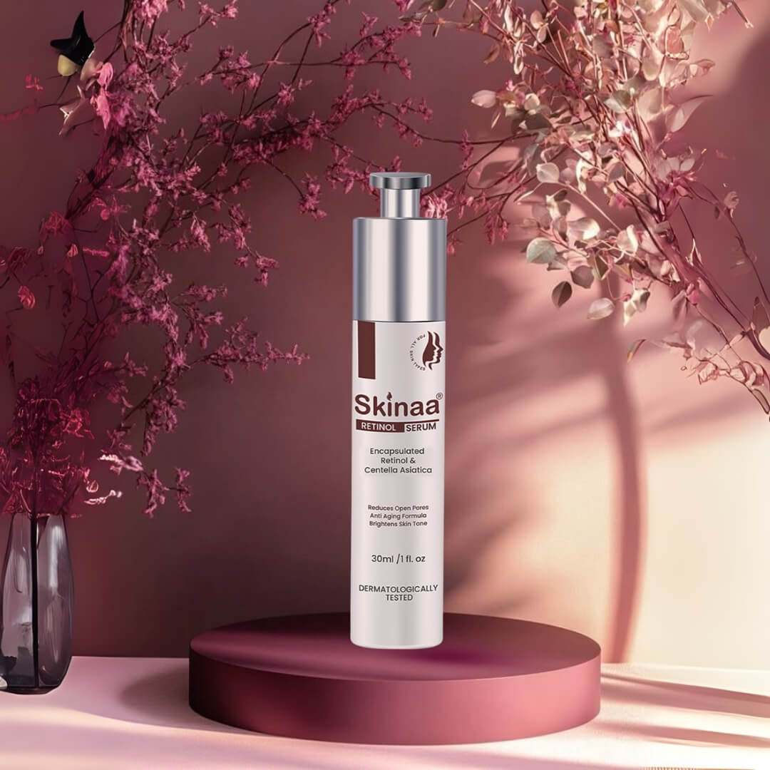 Skinaa Retinol Serum bottle with silver pump placed on a maroon podium, elegant pink floral background, dermatologically tested anti-aging serum for reducing wrinkles, fine lines, and improving skin texture